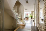 Golden glamourous house hallway with large mirror and garden view